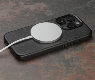 MagSafe charger attached to the Black Slimline Leather Bumper Case for iPhone 15 Pro