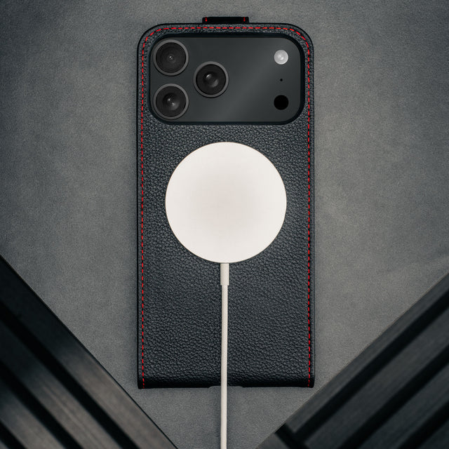 MagSafe charger attached to the Black with Red Stitching Leather Flip Case for iPhone 17 Pro