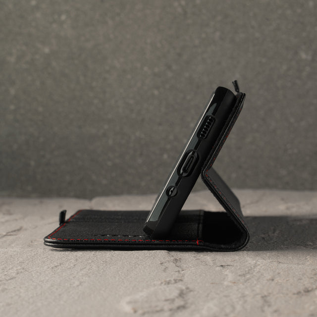 Demonstrating the integrated stand function of the Black Leather (with Red Stitching) Stand Case for Galaxy S20 FE 5G
