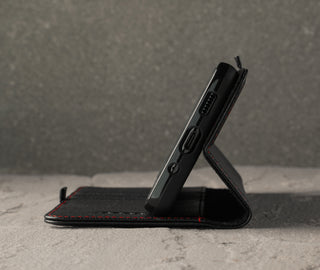 Demonstrating the integrated stand function of the Black Leather (with Red Stitching) Stand Case for Galaxy S20 FE 5G